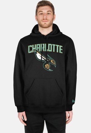 Haut à capuche noir avec "CHARLOTTE" en lettres majuscules au-dessus d'un logo stylisé d'oiseau. Fabriqué en tissu doux, avec une poche avant et une capuche réglable.