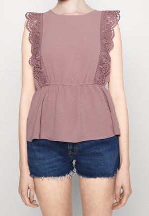 Haut sans manches mauve avec bordure en dentelle sur les épaules et taille froncée, associé à un short en denim bleu foncé avec bords effilochés.