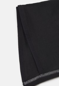 Pezzo di tessuto nero con una sottile trama, caratterizzato da bordi puliti e cuciture a contrasto lungo l'orlo. Progettato per versatilità e strati.