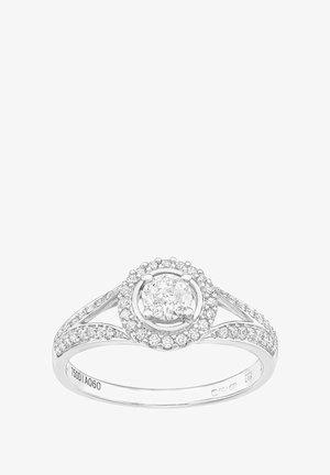 Valgest kullast sõrmus, mille keskel on ümmargune teemant, mille ümbritsevad väiksemad teemandid, keeruka bändi disainiga ja poleeritud viimistlusega.