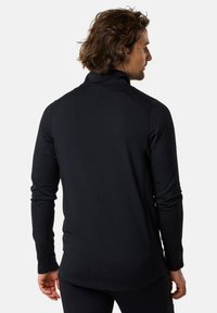 Black long-sleeve shirt with a high collar and a textured surface. Fitted design with raglan sleeves and a slightly curved hem.