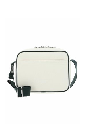 Sac bandoulière rectangulaire blanc avec une bordure noire, une sangle réglable vert foncé et un logo Lacoste embossé à l'avant.