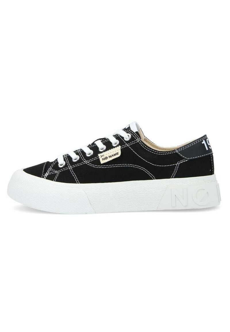 Baskets noires en toile avec accents blancs, semelle en caoutchouc et couture visible. Présente un patch logo et un détail en relief sur le talon.
