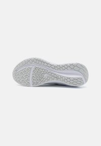 Talpa de sneaker din cauciuc alb, cu un model texturat ce include desene hexagonale și liniare pentru aderență și durabilitate.