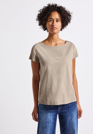 Beige bomulds t-shirt med rund halsudskæring og korte ærmer; har lys trykt tekst "ICONIC Confidence" på tværs af brystet.