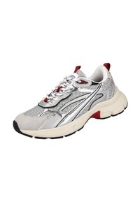 Zapatilla deportiva con una parte superior de malla plateada, acentos de ante gris, detalles rojos, una suela blanca gruesa y una banda de rodadura negra contrastante.