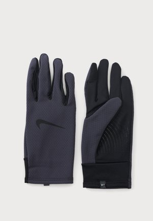 Paire de gants Nike gris foncé et noirs, tissu texturé sur le dessus, motif antidérapant sur la paume, logo Nike visible au dos du gant gauche.