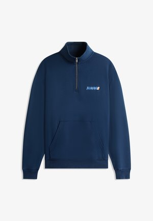 Tengerészkék, negyed cipzárral ellátott pulóver kenguruzsebbel és kis "TOMMY" logóval a bal mellrészen, bordázott mandzsettákkal és szegéllyel.