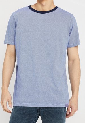 Kortærmet blå stribet t-shirt med en marineblå rund halsudskæring, der har en blød tekstur og et lille lilla mærke ved den nederste kant.