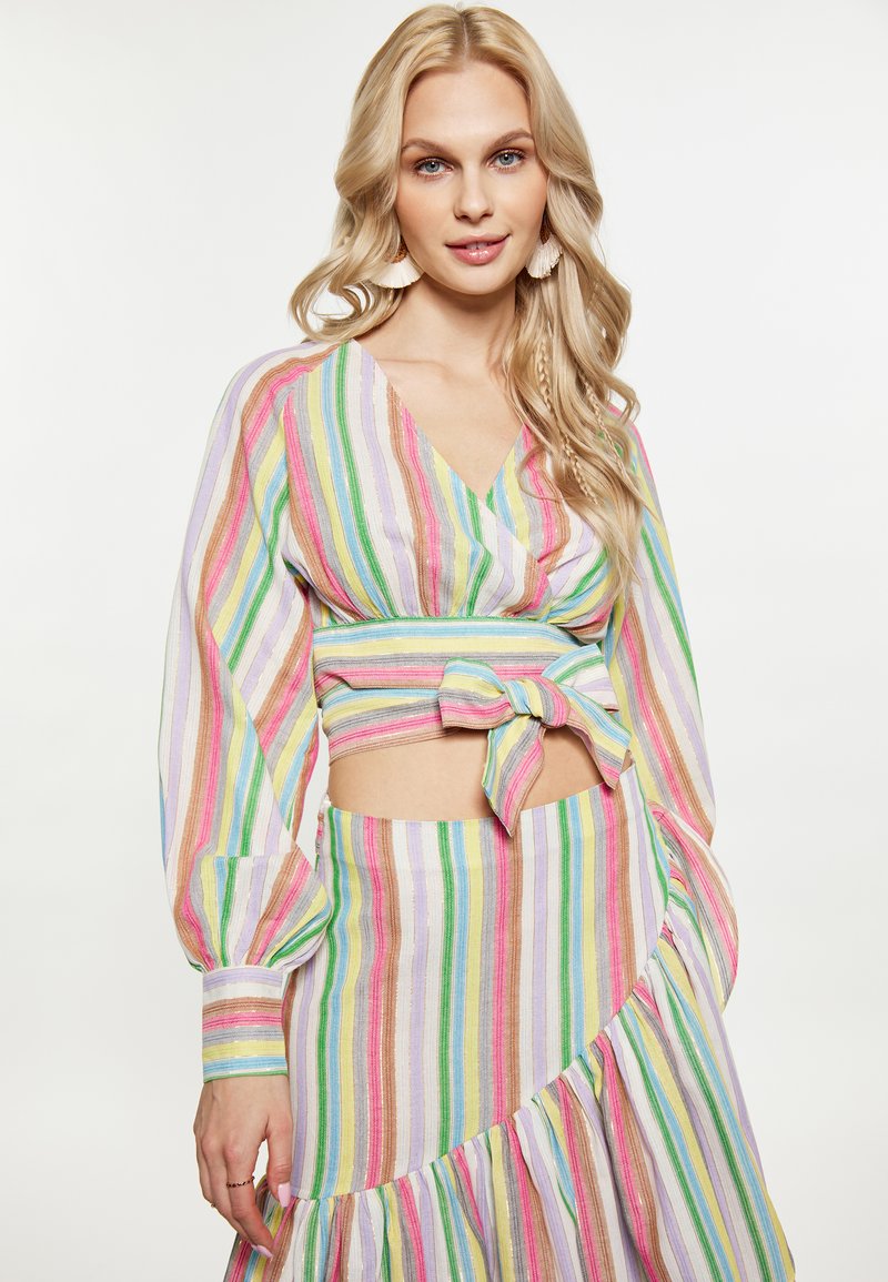 Completo a due pezzi a righe in colori pastello composto da una blusa avvolgente con maniche lunghe e una gonna con orlo arricciato. Tessuto leggero.