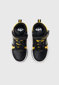 Sneaker alte nere e gialle con una cinghia, dotate di un logo di Batman, chiusura con lacci, collo imbottito e suola in gomma testurizzata.