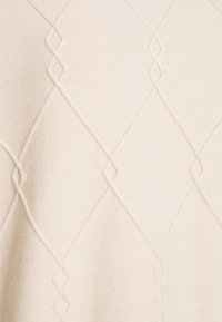 Knit sweater in light cream, featuring a diamond pattern with textured detailing. Smooth fabric with a soft finish.