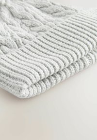 Lichtgrijze gebreide beanie met een geribbelde rand. Beschikt over een textuur van kabelpatroon, zachte garen en een strakke pasvorm.