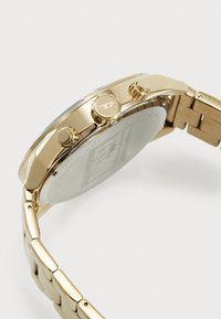 Orologio da polso dorato con cassa rotonda e quadrante blu, due pulsanti e bracciale in metallo a maglie. Finitura liscia e fondo in vetro.