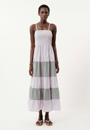 Robe maxi avec un corsage smocké, des fines bretelles et un design à volants avec des rayures horizontales alternées en blanc, rose et gris.