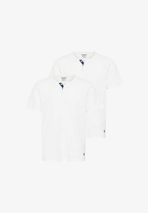 Weißes Kurzarm-Henley-Shirt mit Rundhalsausschnitt und navyfarbenem Knopfakzent, kombiniert mit hellblauen Jeans und weißen Sneakern.