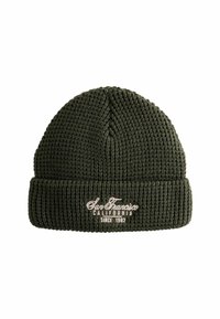 Bonnet en tricot vert avec une texture côtelée, présentant un revers tourné et un texte brodé indiquant "San Francisco Californie Depuis 1982."