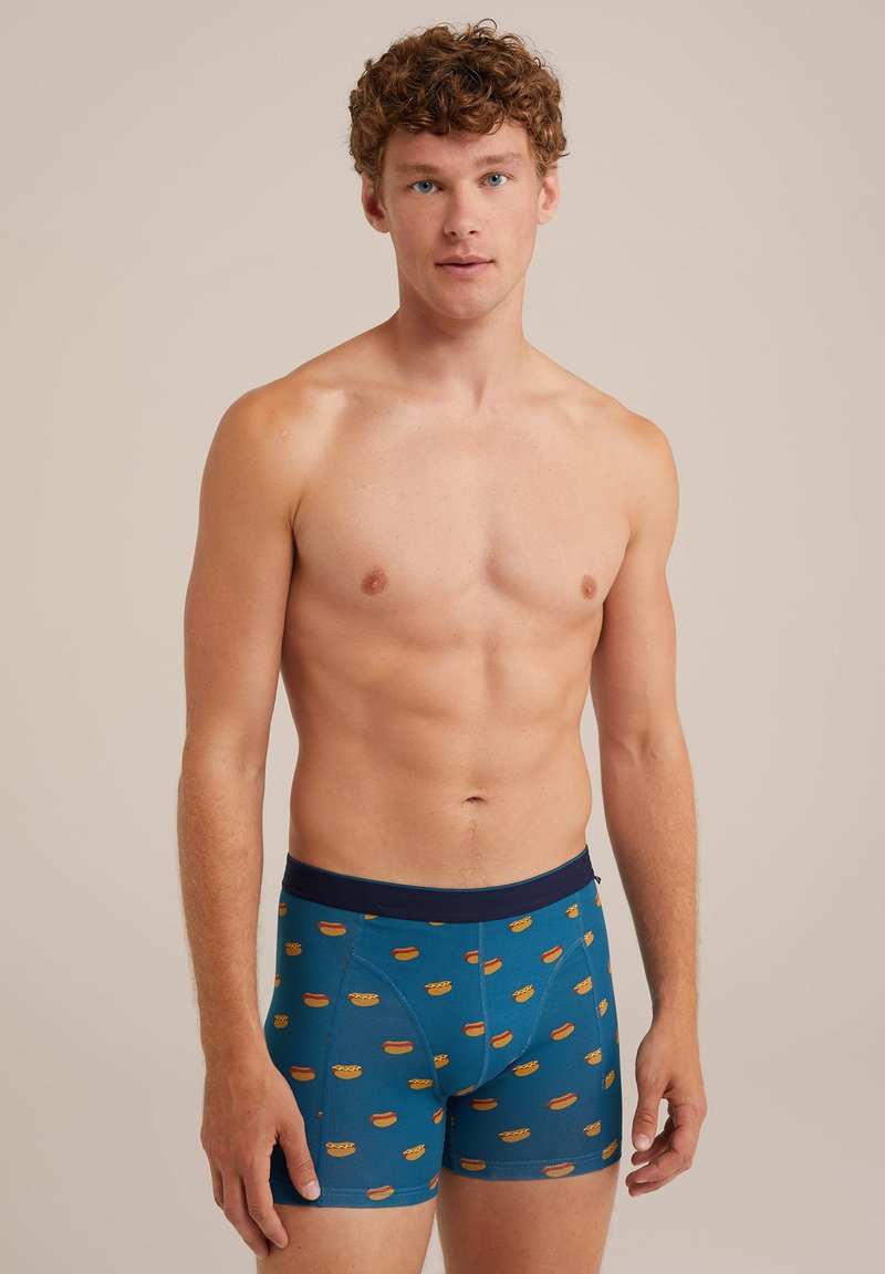 Kék anyagú boxer alsó, amelyet ismétlődő hot dog mintázat díszít; elasztikus derékpánt; sima textúra; testhez simuló forma.