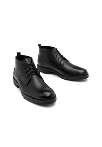 Czarne skórzane botki za kostkę o gładkim wykończeniu, z sznurowaniem, okrągłym noskiem i teksturowaną podeszwą dla lepszej przyczepności.