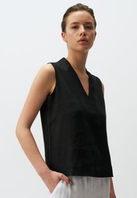 Zwarte mouwloze top met een V-hals ontwerp, gemaakt van textiel met structuur, met een rechte snit en subtiele stiksels.