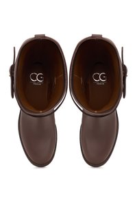 Brown leather ankle boots with a smooth finish, round toe, and a strap detail. Interior features a branded insole with "CG PREMIUM."