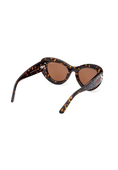 Gafas de sol de carey con forma de ojo de gato, lentes marrones y acabado brillante. Presenta herrajes plateados con el logotipo de la marca en el costado.