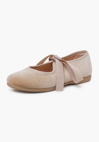 Bailarinas en suave terciopelo beige con punta redondeada. Cuentan con una delgada correa de tela en el tobillo para un ajuste seguro y una suela flexible.