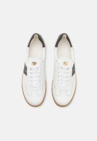 Sneakers in pelle bianca con tacco nero e strisce laterali, dotati di lacci e suola in gomma testurizzata. Branding dorato sul lato.