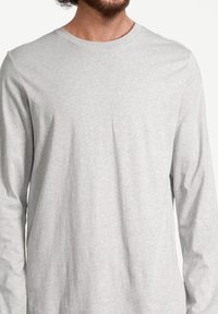 Lichtgrijs langslavend shirt made van zachte katoen stof, met een ronde halslijn en een losse pasvorm.
