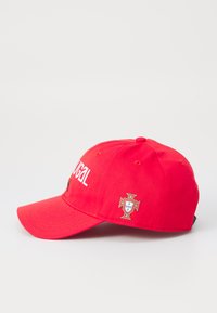 Căciulă de baseball roșie cu cuvântul "Portugalia" scris cu litere albe, cu o margine curbată și un emblema națională cu accente aurii pe lateral.