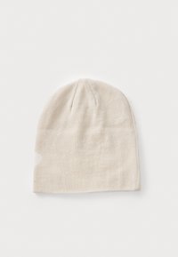 Beige strikindx med tætsiddende pasform, der har en enkel struktur og en sømløs top. Accent med et lyst mønster på den ene side.