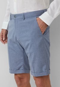 Hellblaue Shorts aus strukturiertem Stoff mit dezentem Muster. Sie verfügen über einen Knopfverschluss, seitliche Taschen und umgeschlagene Säume.