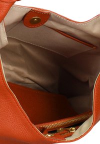Sac à main en cuir orange avec un extérieur texturé, une doublure en tissu beige et une poche zippée à l'intérieur. Doté d'une fermeture magnétique.