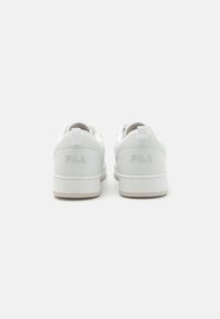 Baskets en cuir blanc au fini lisse, avec un talon texturé, des lacets plats et un logo Fila subtilement embossé à l'arrière.
