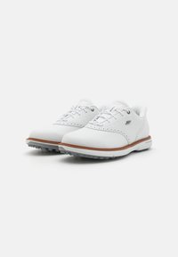 White leather golf shoes with perforated designs, gray soles, and brown accents. Laces feature multiple eyelets for secure fit.