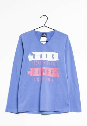 Chemise à manches longues bleue avec un col en V ; présente un texte graphique blanc et rose "QUIK BOARDRIDING SILVER COMPANY" dans un design superposé.