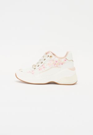 Hvid chunky sneaker med lyserød blomstermotiv og guld dragebroderi, cremefarvede snørebånd og beige sål, vist fra siden på en hvid baggrund.