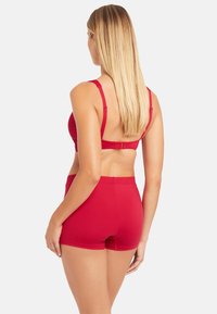 Roter BH und passendes Shorts-Set mit glatter Textur, verstellbaren Trägern und schlichter Bandgestaltung. Ansicht von hinten.