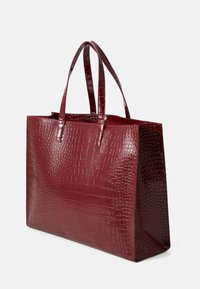 Saco tote bordeaux com padrão de crocodilo e acabamento de alto brilho, com duas alças resistentes e forma retangular. Apresenta um design minimalista.