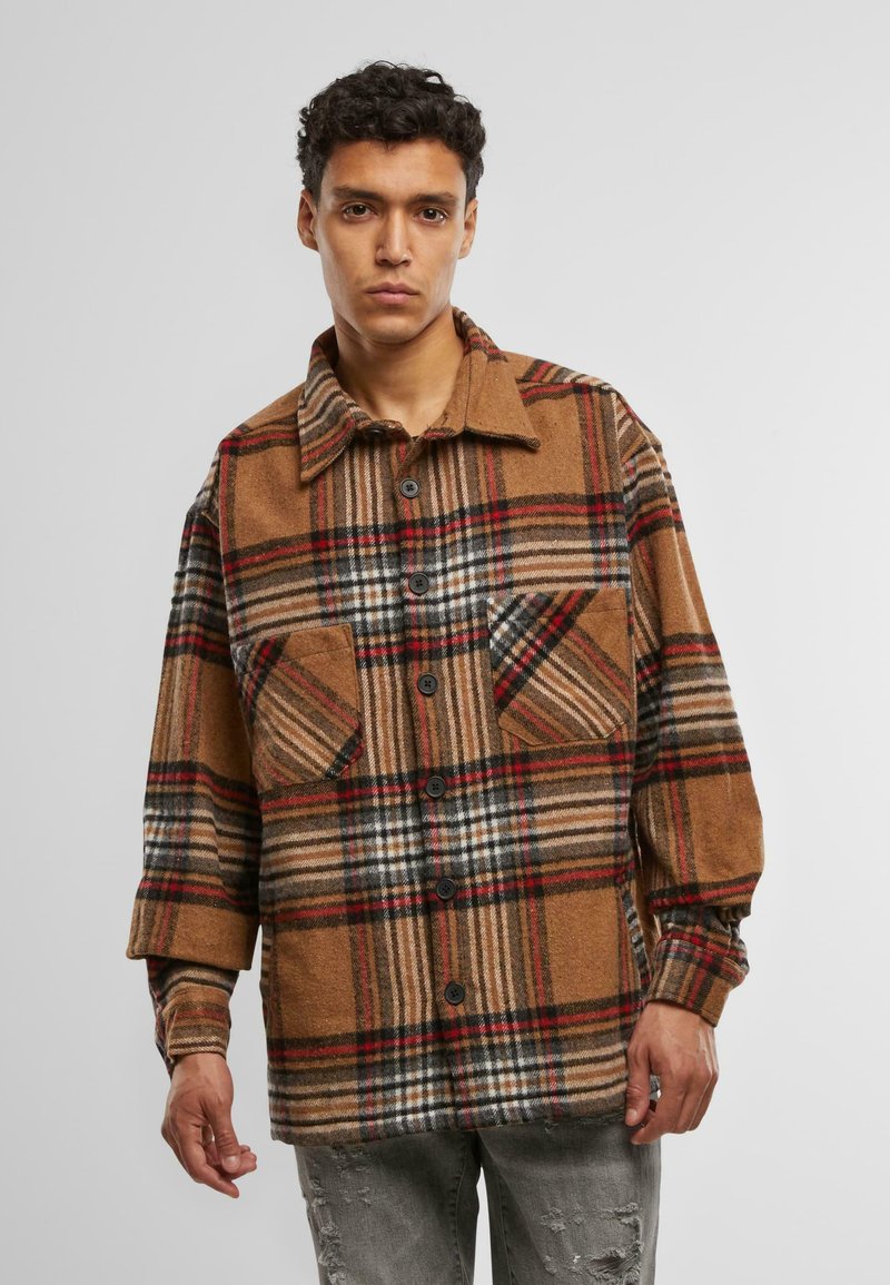 Bruine en zwarte geruite shirtjas van een wolmix, met twee voorzakken, knoopsluiting en een omklapbare kraag. Gestructureerd ontwerp.