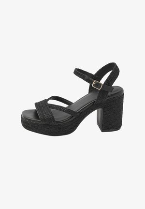 Zwarte sandaal met hoge hak en gevlochten textuur, open teen, enkelriem met gouden gesp en stevige blokhak.