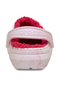 Białe i różowe Crocs z teksturowaną powierzchnią, puszystym różowym wyściółką oraz szerokim paskiem. Charakteryzują się marmurkowym wzorem na zewnętrznej stronie.