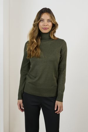 Maglione a collo alto di un verde scuro, a coste, con maniche lunghe, design aderente e tessuto testurizzato. Abbinato a pantaloni neri.