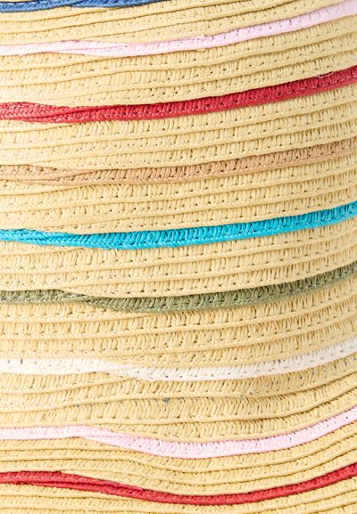 Κοντινό πλάνο υφαντού καπέλου από άχυρο με οριζόντιες πολύχρωμες ρίγες σε κόκκινο, ροζ, ταμπά, μπλε, πράσινο και λευκό.