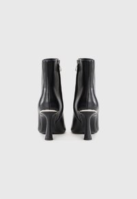 Black leather ankle boots with a high, chunky heel. Features a sleek design, zip closure at the back, and smooth, glossy texture.