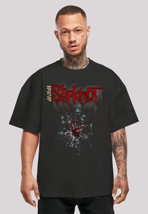 Black oversized t-shirt featuring a red "Slipknot" logo and a shattered glass pattern with blood splatter detail on the front.