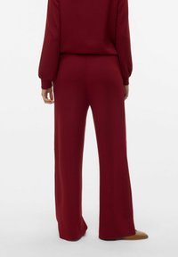 Bordeaux brede broek gemaakt van zachte stof, met een hoge taille en lange lengte, met minimale zichtbare naden en een gladde textuur.