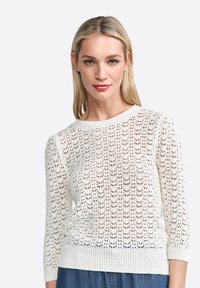 Maglione bianco lavorato a maglia con un motivo a pizzo aperto, scollatura a girocollo e maniche a tre quarti con polsini e orlo a coste.