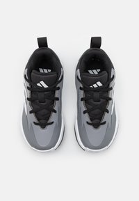 Baskets de sport au design épuré avec une tige synthétique grise, une languette en maille noire, des accents blancs et des lacets noirs.