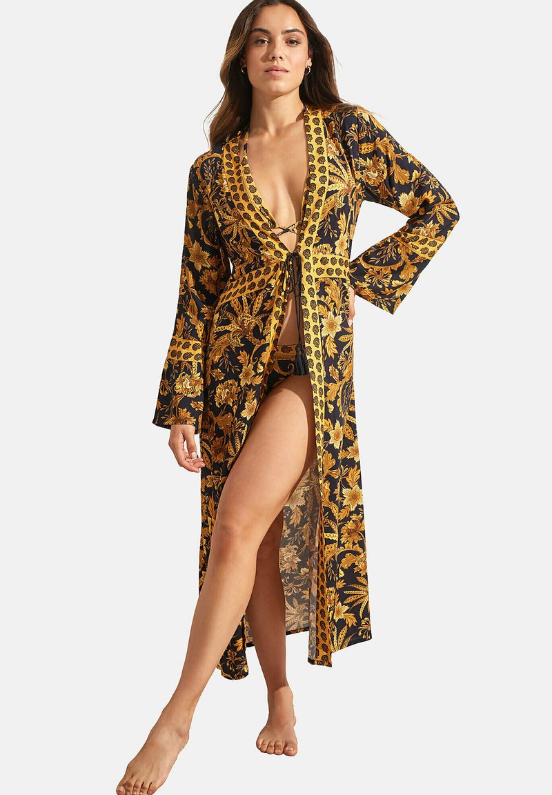 Bloemdruk kimono in zwart en goud, met een diepe V-hals, lange klokmouwen en een strikdetail rond de taille.
